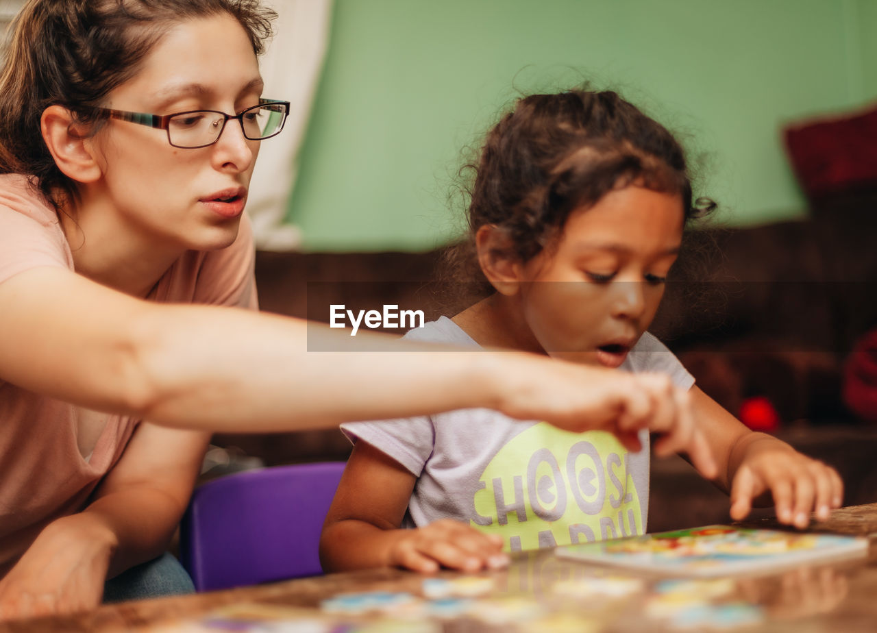 Mother assisting daughter in studies at home