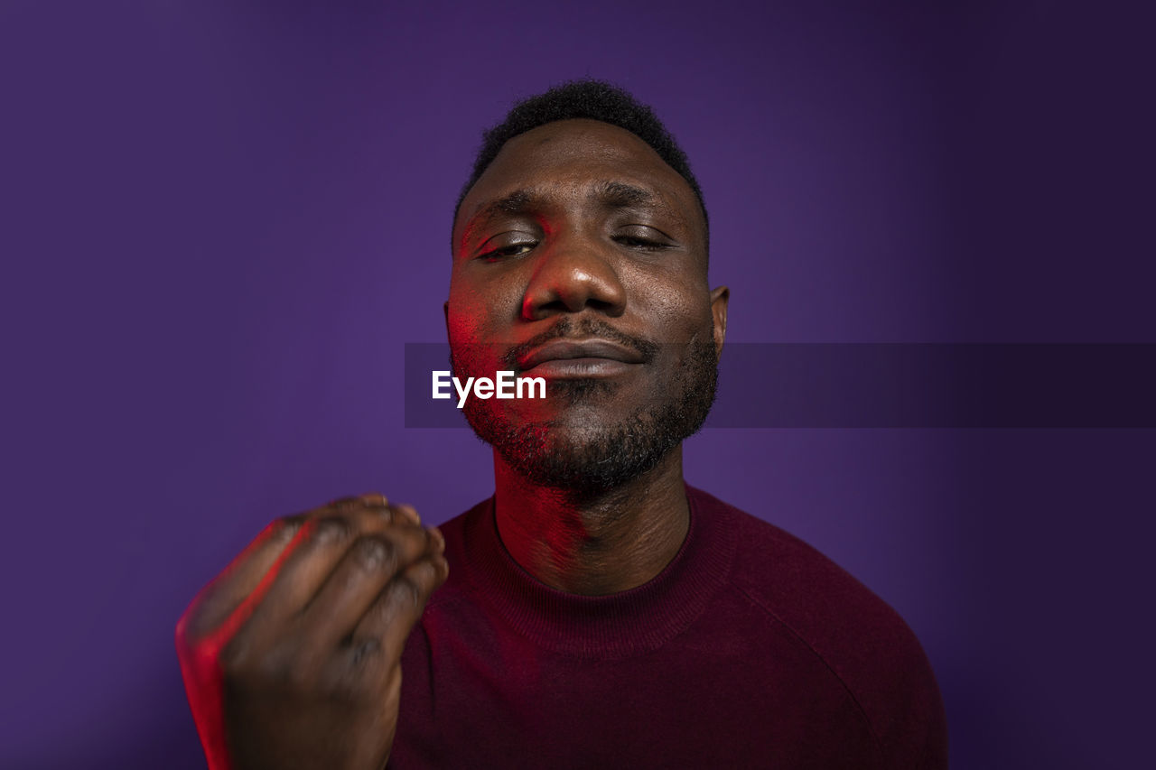 Young black man showing chef taste approval hand gesture. isolated background. medium shot.