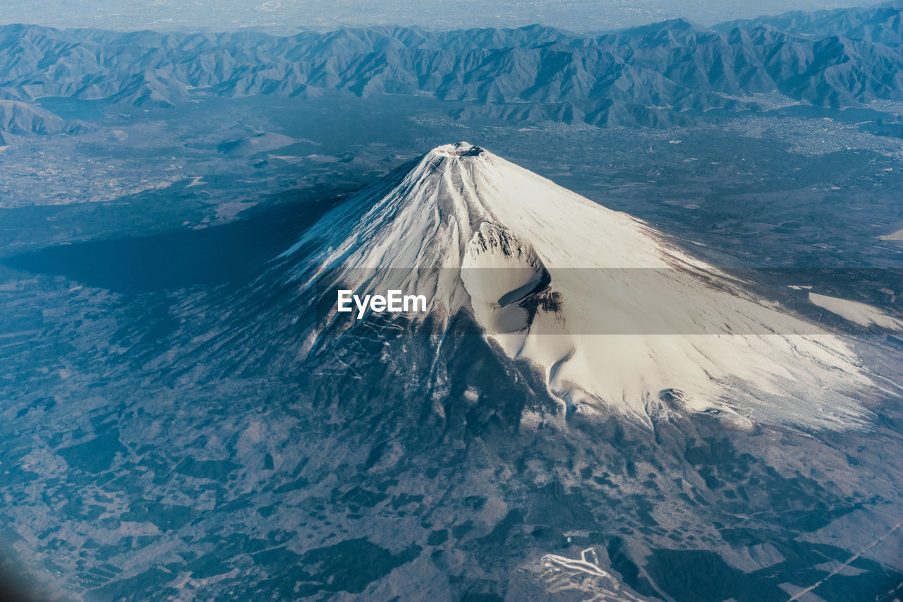 High angle view of woman on snowcapped mountain fuji by sea