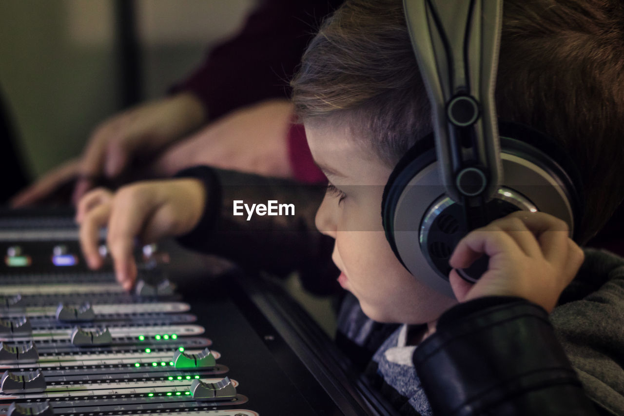 Cute boy mixing music in recording studio