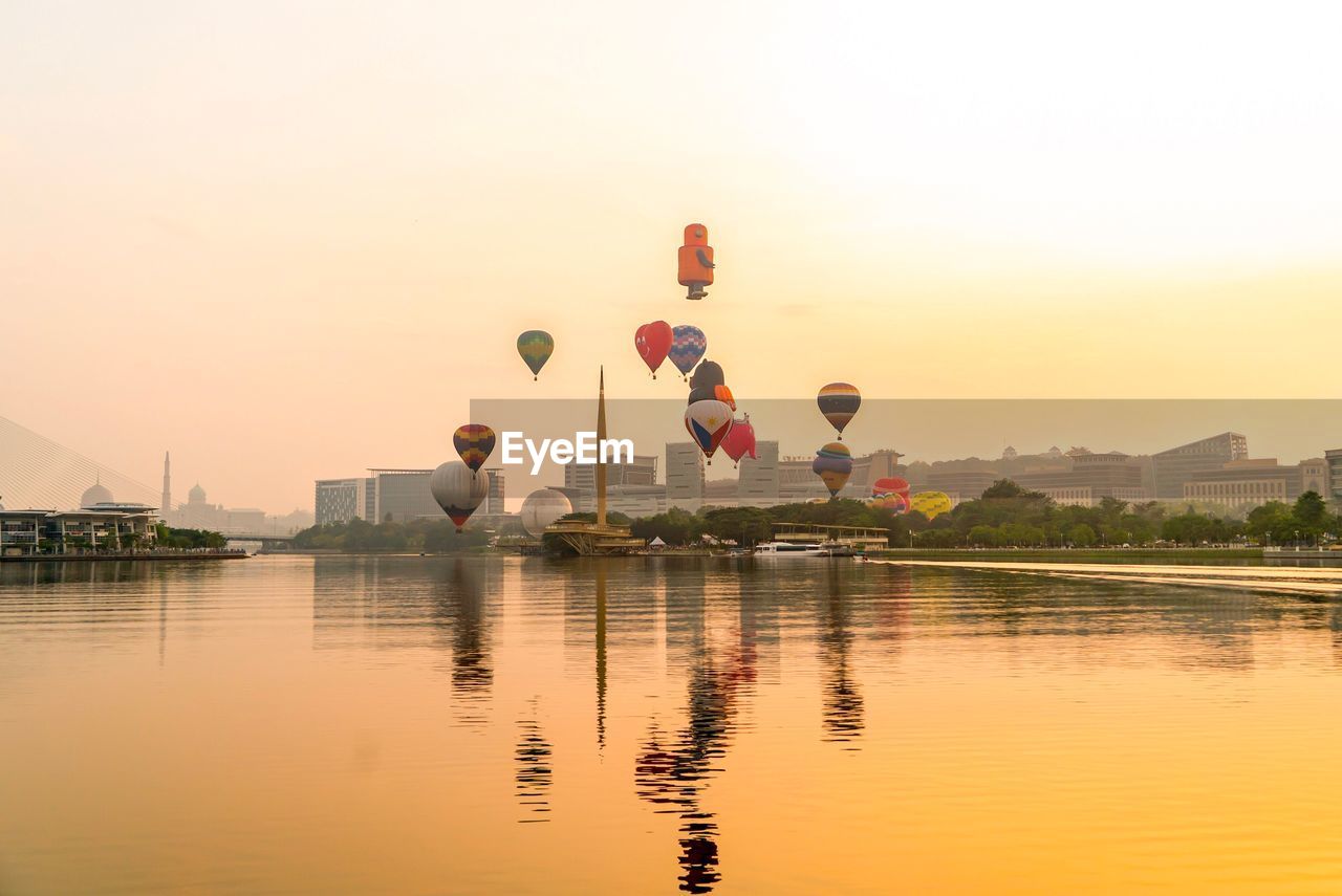 VIEW OF HOT AIR BALLOON IN LAKE AT SUNSET