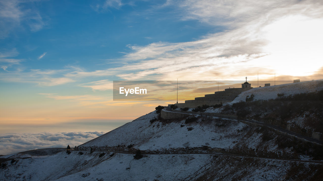 ABANDONED BUILDING DURING WINTER AGAINST SKY