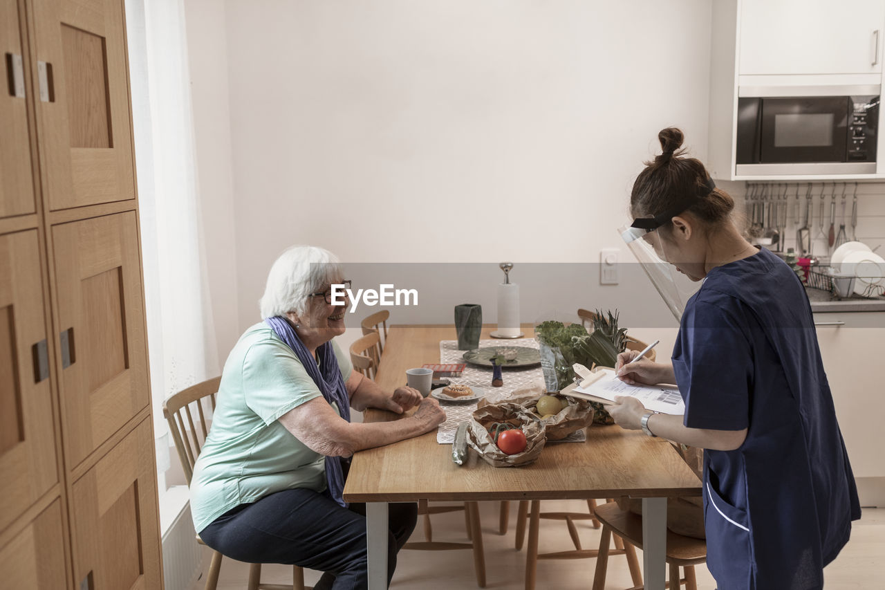 Home carer helping senior woman at home