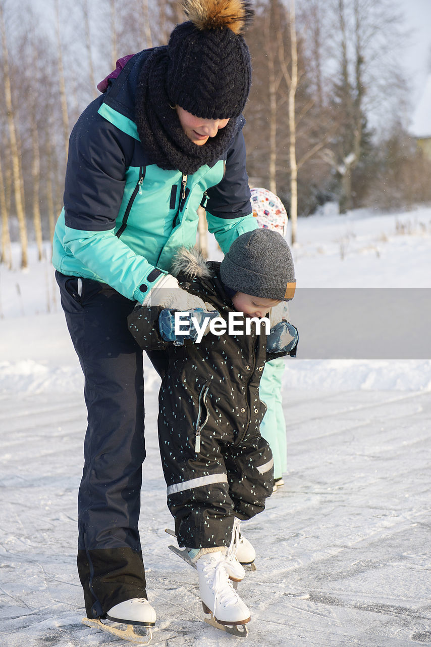 Full length of boys on snow covered field during winter