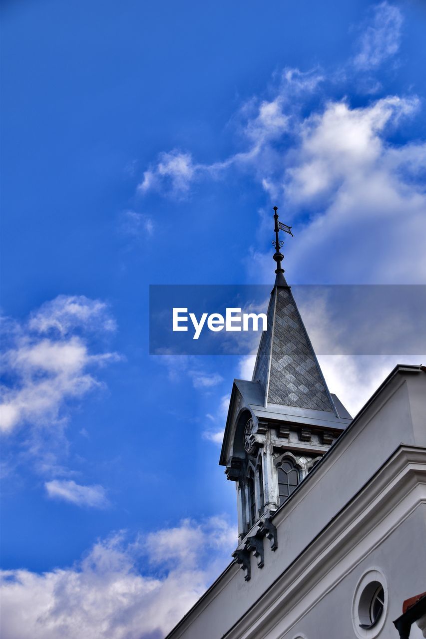 sky, architecture, blue, cloud, built structure, building exterior, building, place of worship, religion, belief, tower, nature, low angle view, no people, spirituality, steeple, day, spire, outdoors, travel destinations, cross, history, the past, catholicism, city, time