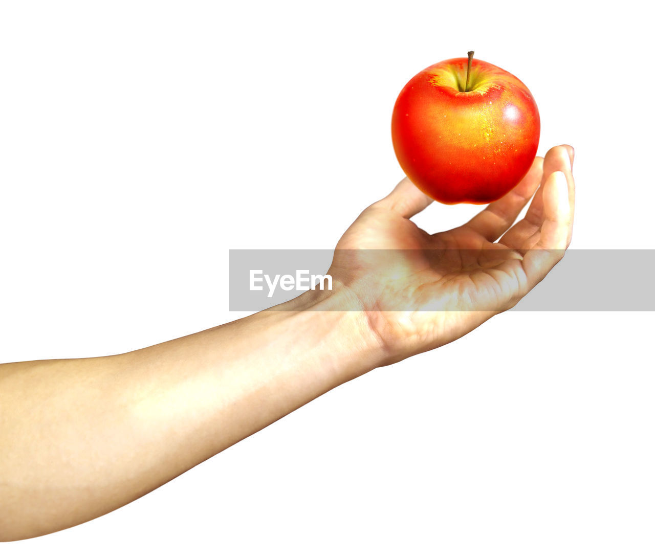 Close-up of hand holding apple against white background