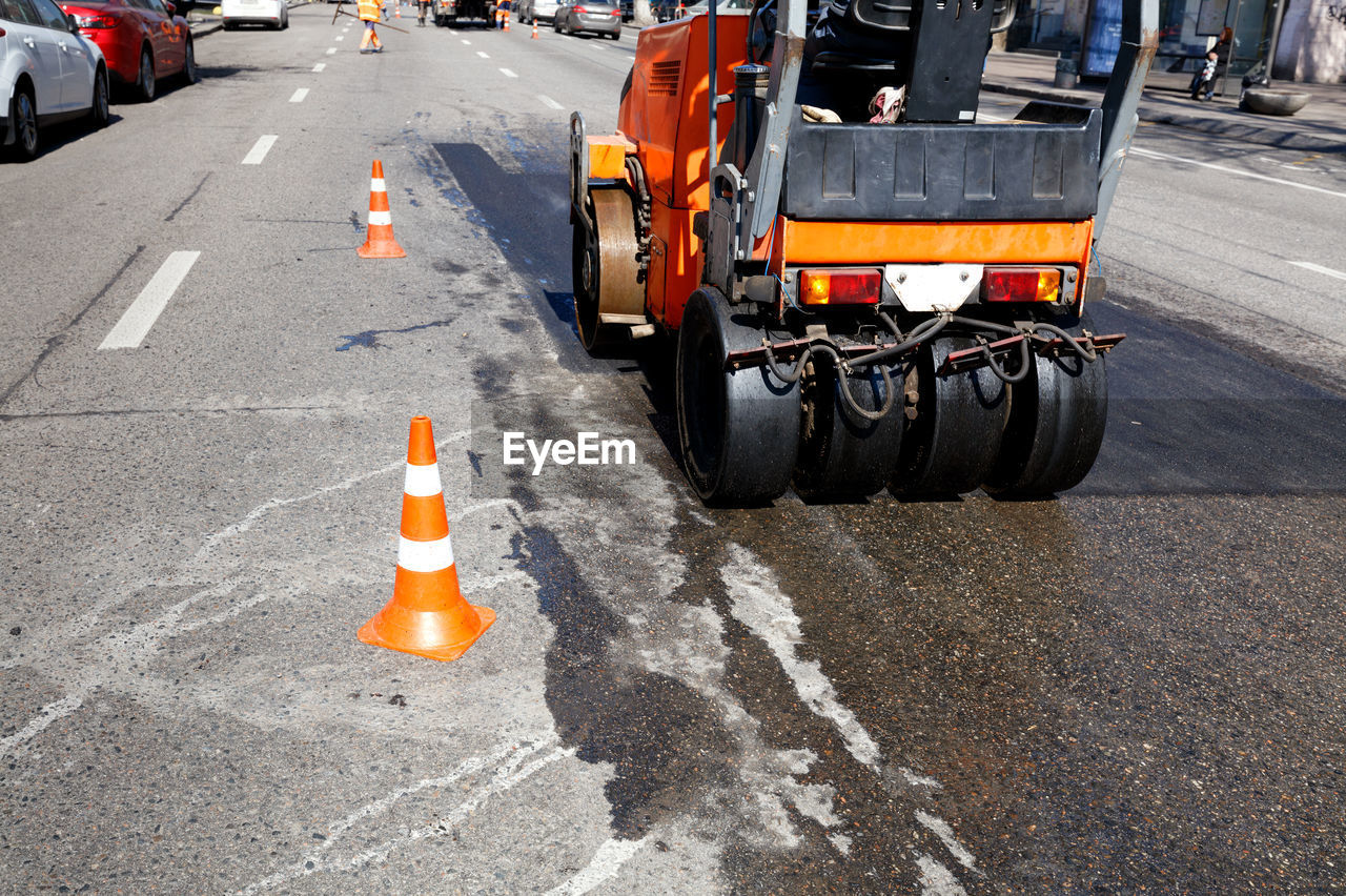 High angle view of construction vehicle by traffic cones on street