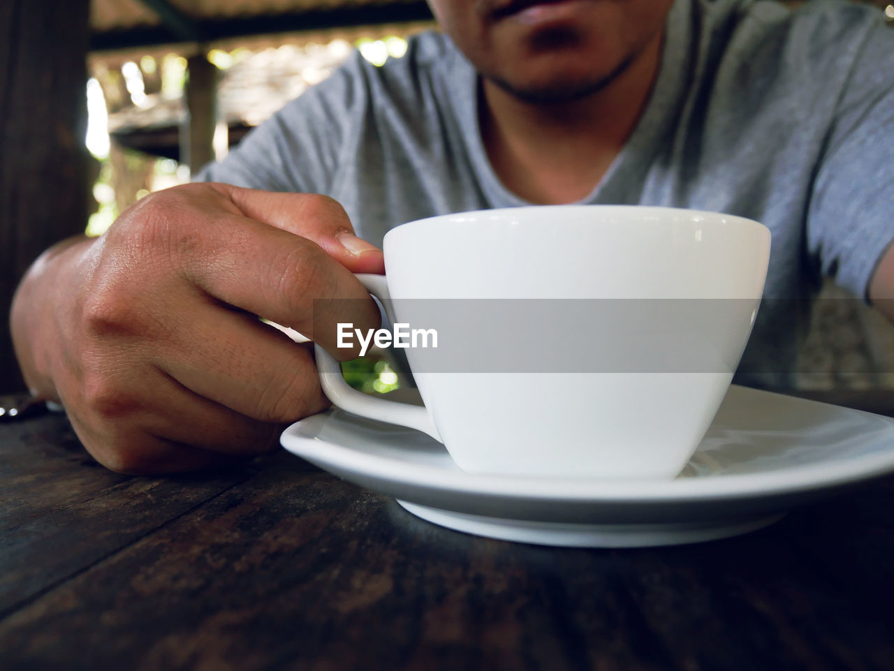 CROPPED IMAGE OF MAN HOLDING COFFEE CUP WITH TEA