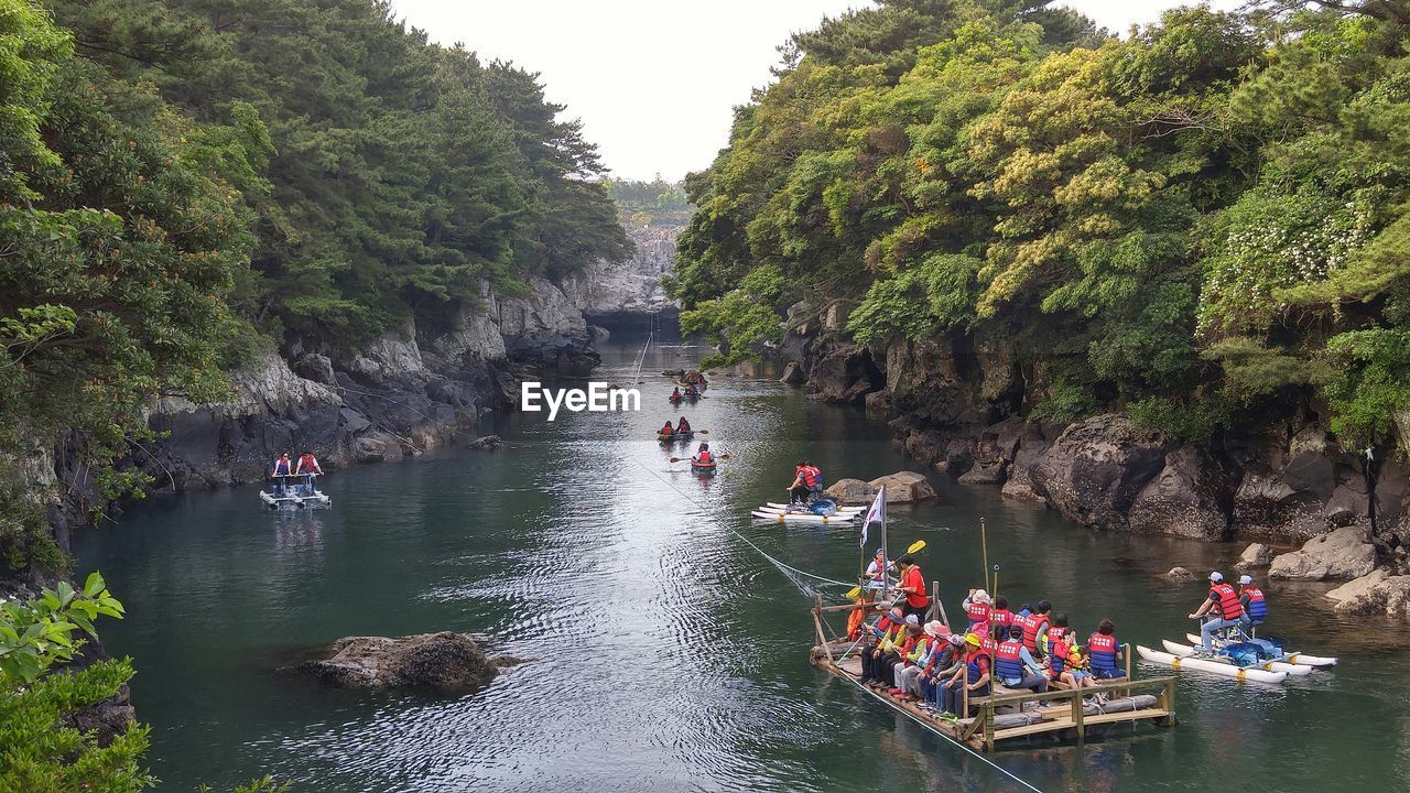 PEOPLE ON BOATS IN RIVER