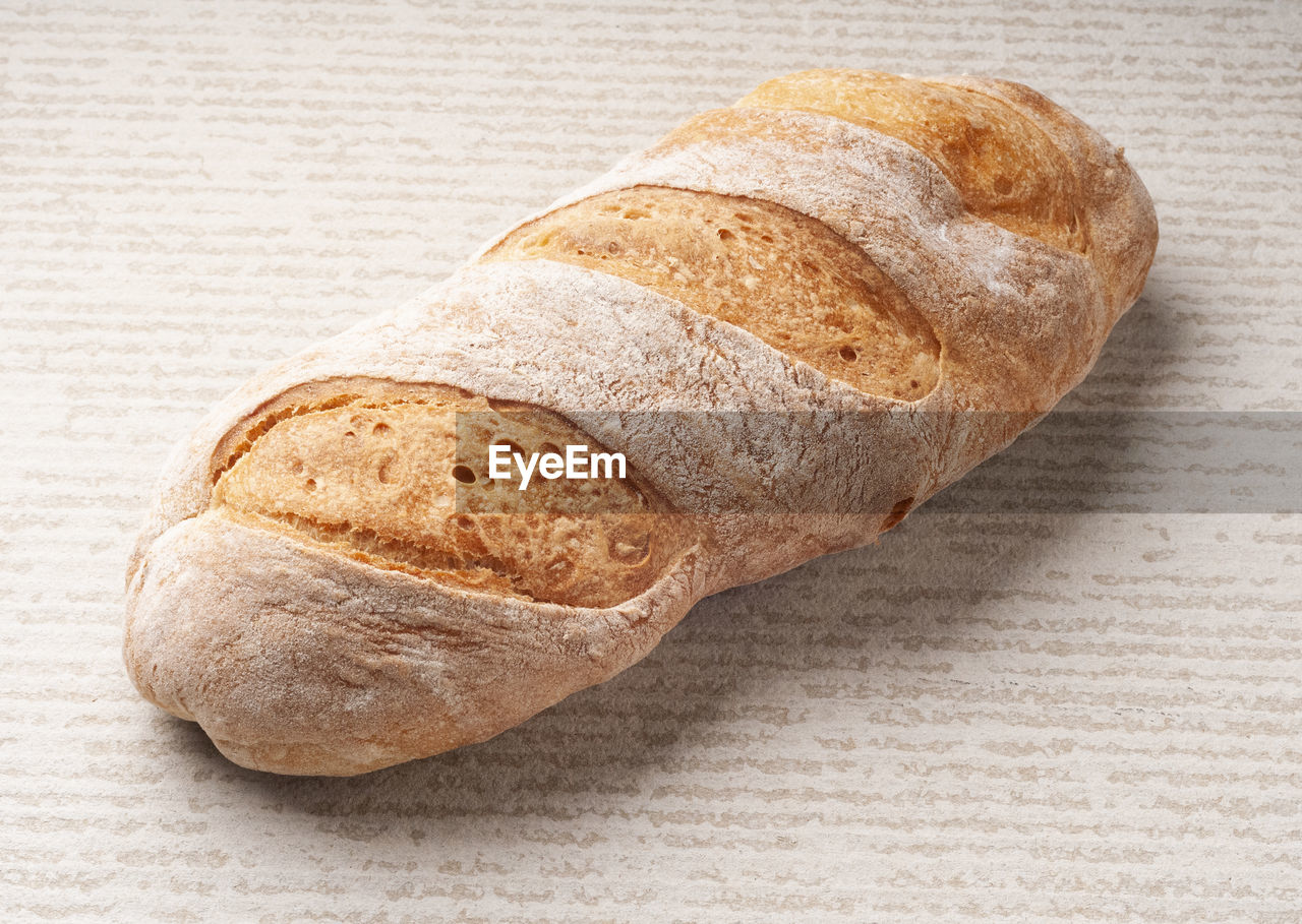 food and drink, bread, food, baked, freshness, loaf of bread, indoors, close-up, healthy eating, rye bread, wellbeing, still life, baguette, no people, ciabatta, table, brown, whole grain, french food, studio shot, single object, simplicity, wood, brown bread, high angle view, bakery