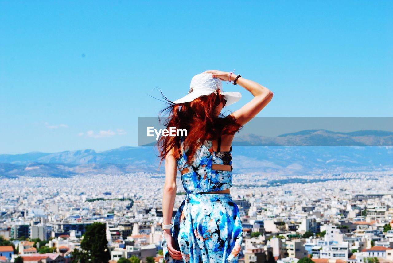 Rear view of woman looking at city view against sky