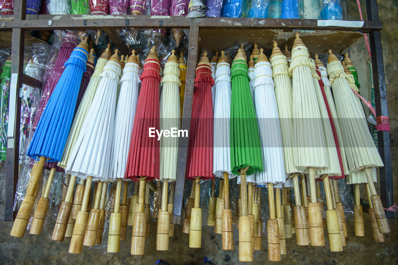 Multi colored umbrellas hanging in market for sale