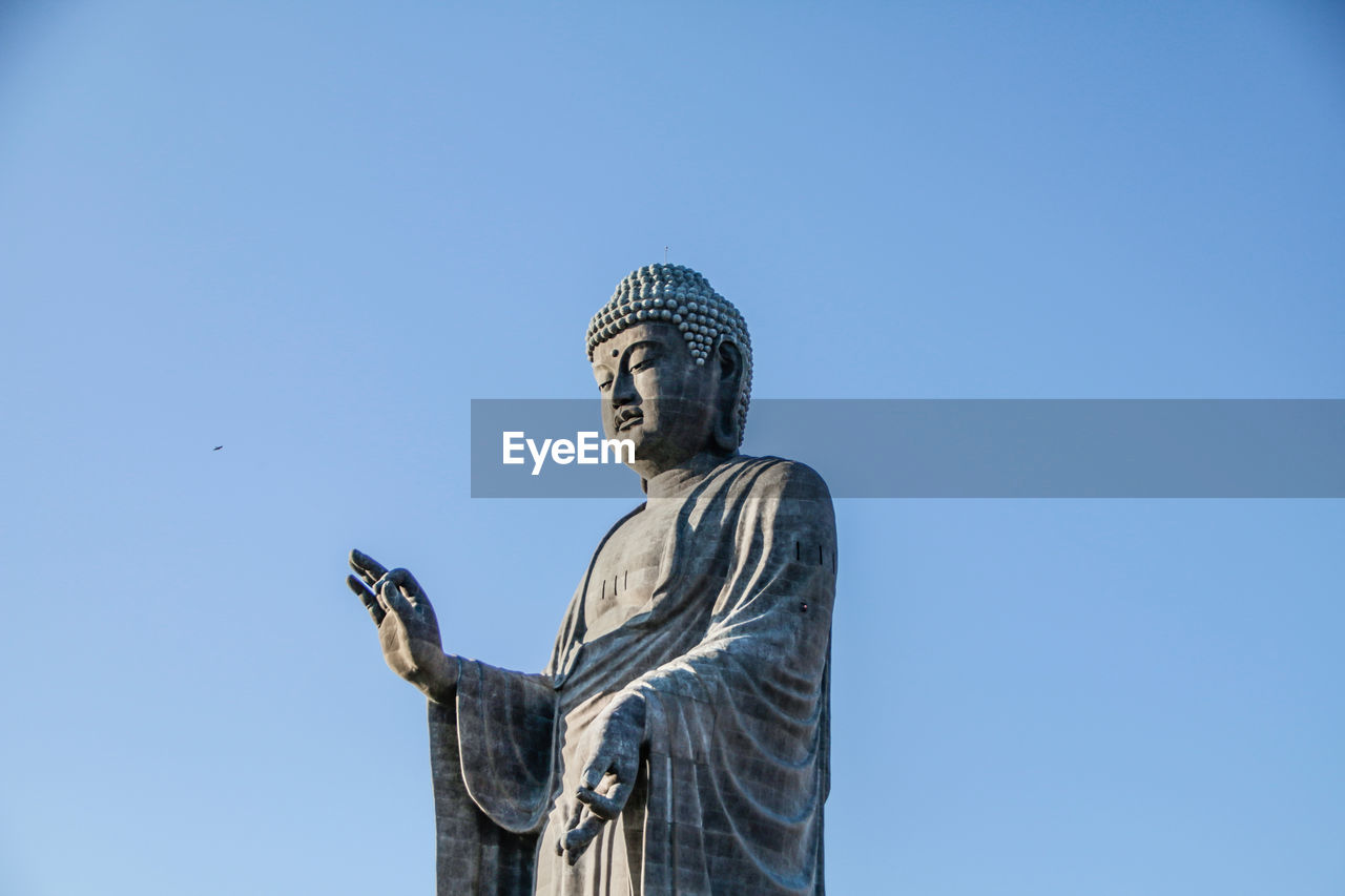 low angle view of young woman against clear sky