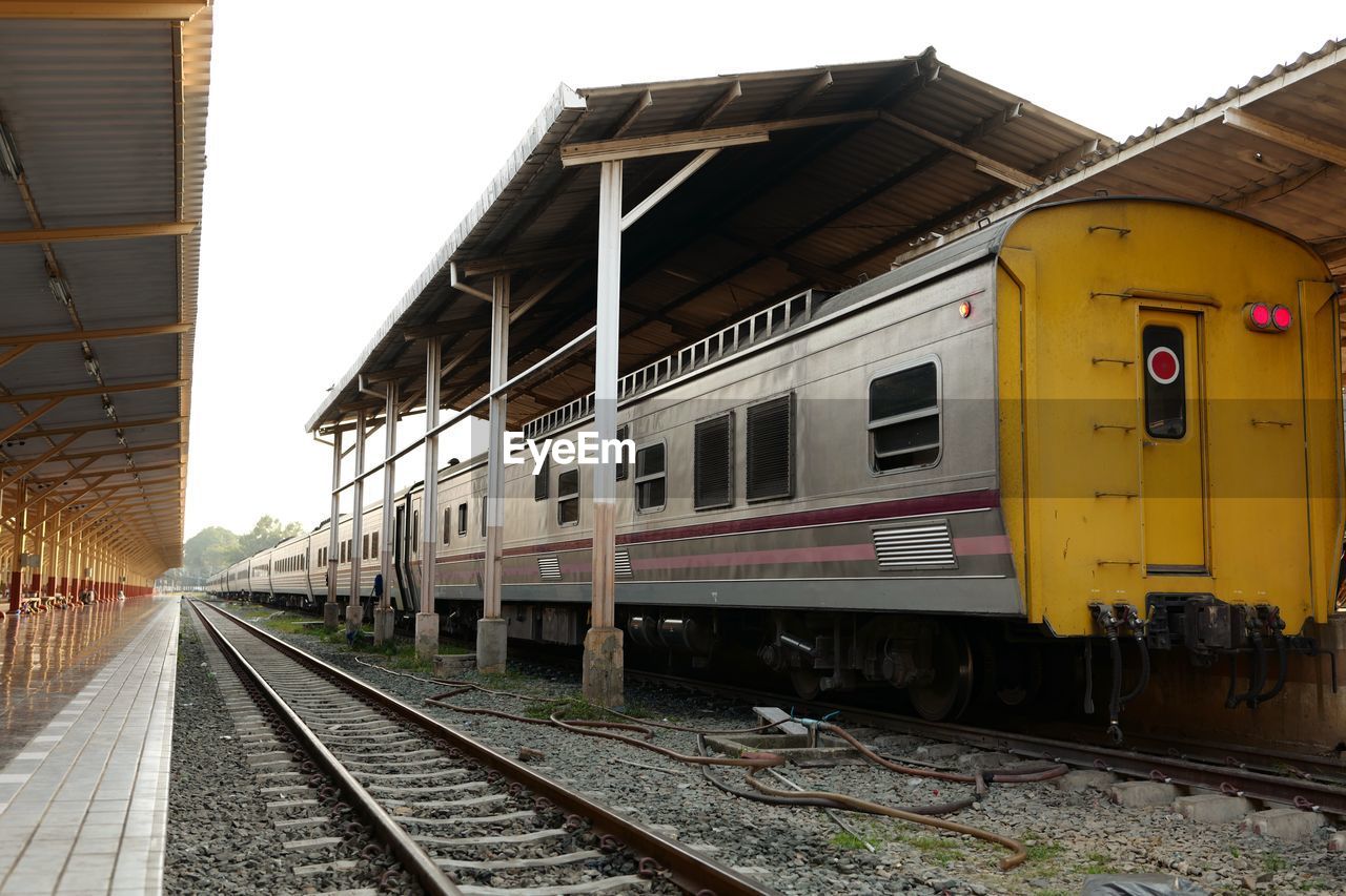 TRAIN AT RAILROAD STATION PLATFORM AGAINST CLEAR SKY