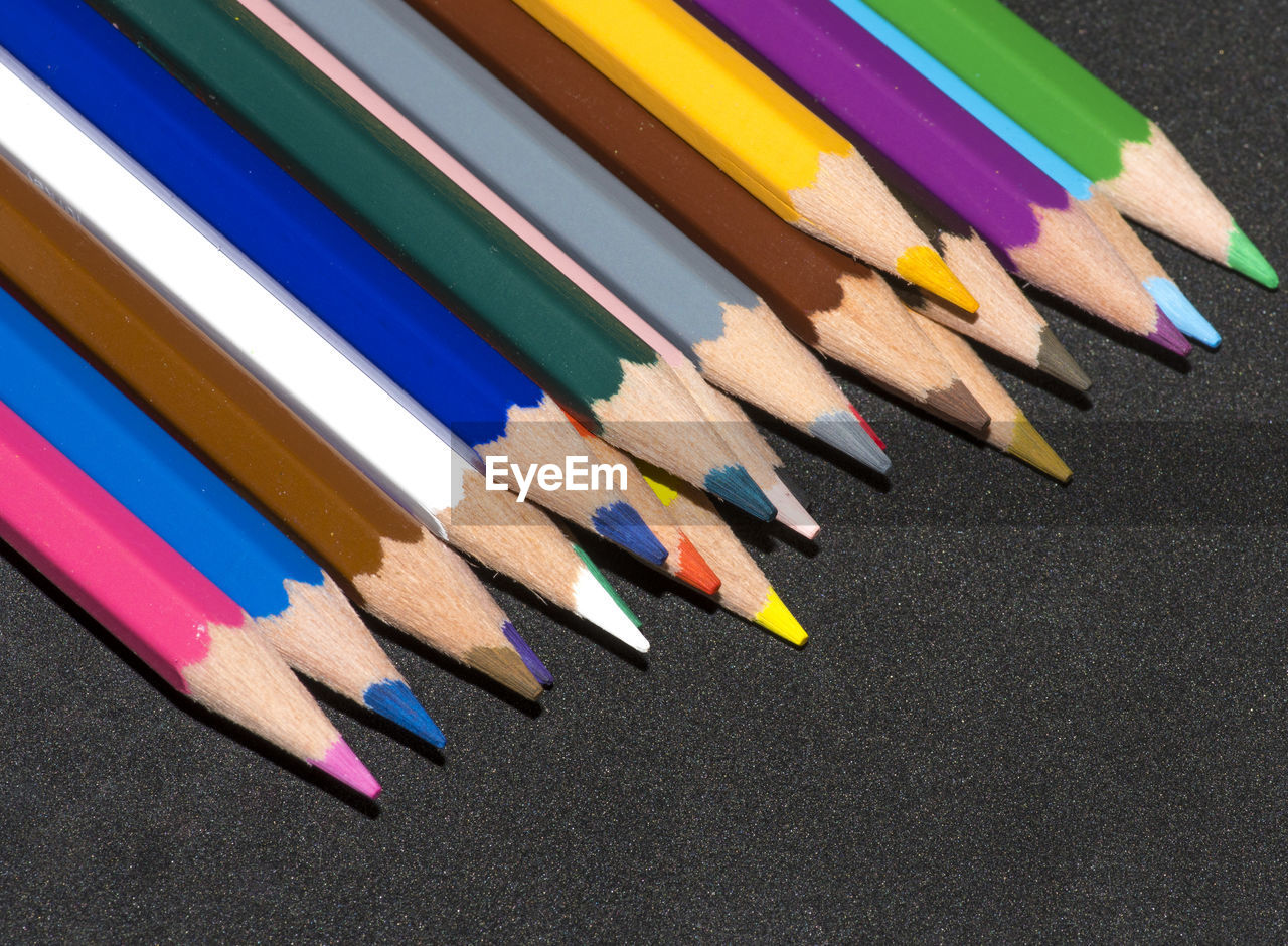 HIGH ANGLE VIEW OF MULTI COLORED PENCILS ON SHELF