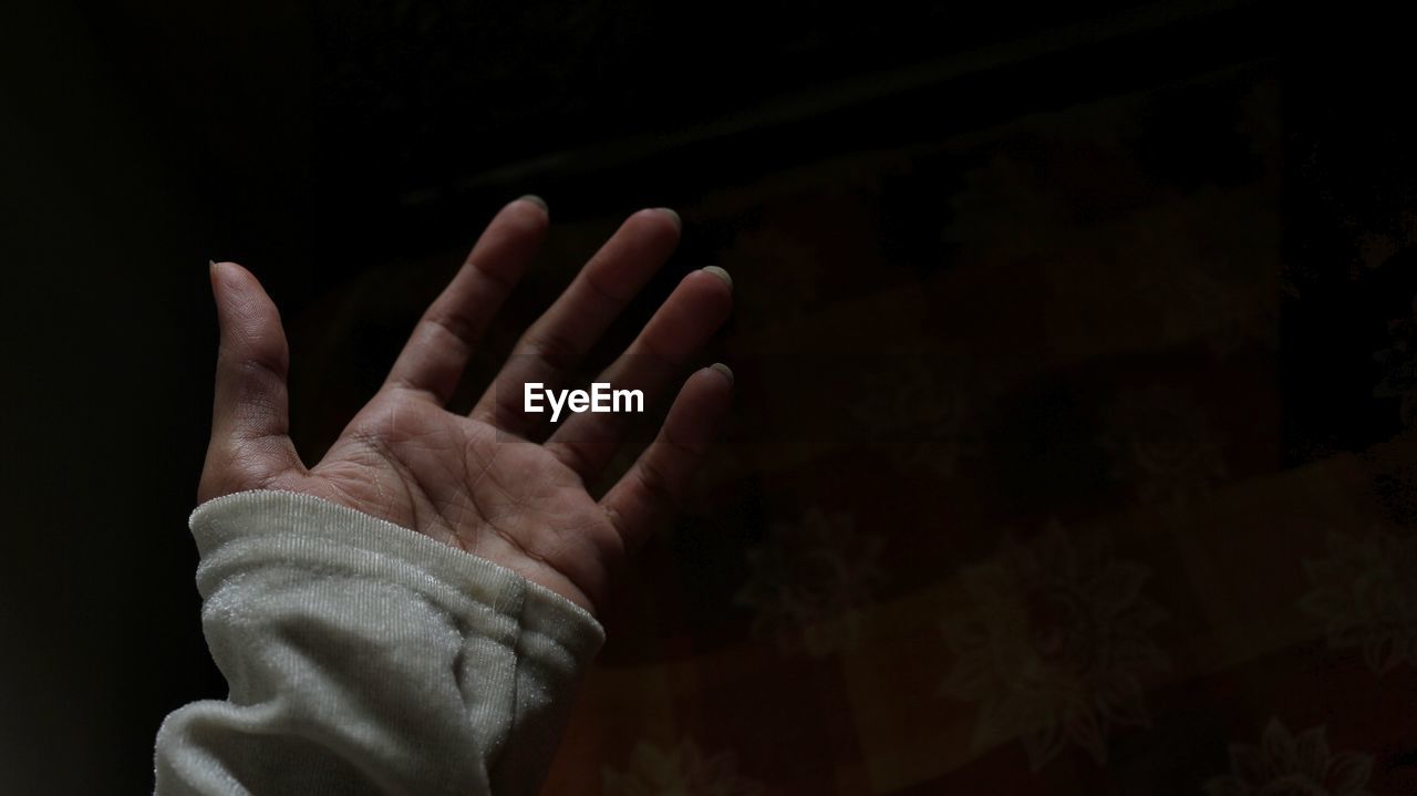 Close-up of person hand against black background