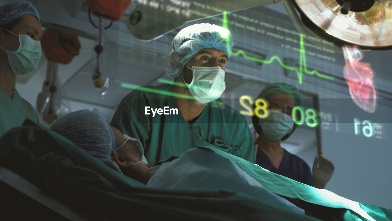 A surgeon diagnose a woman's heart problem via a holographic body scan before surgical procedure