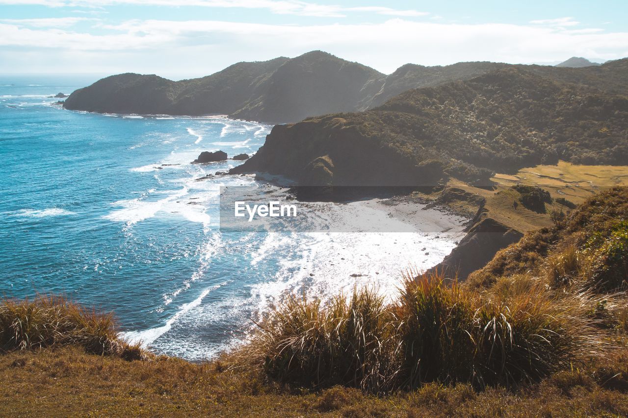 Scenic view of sea and mountains against sky