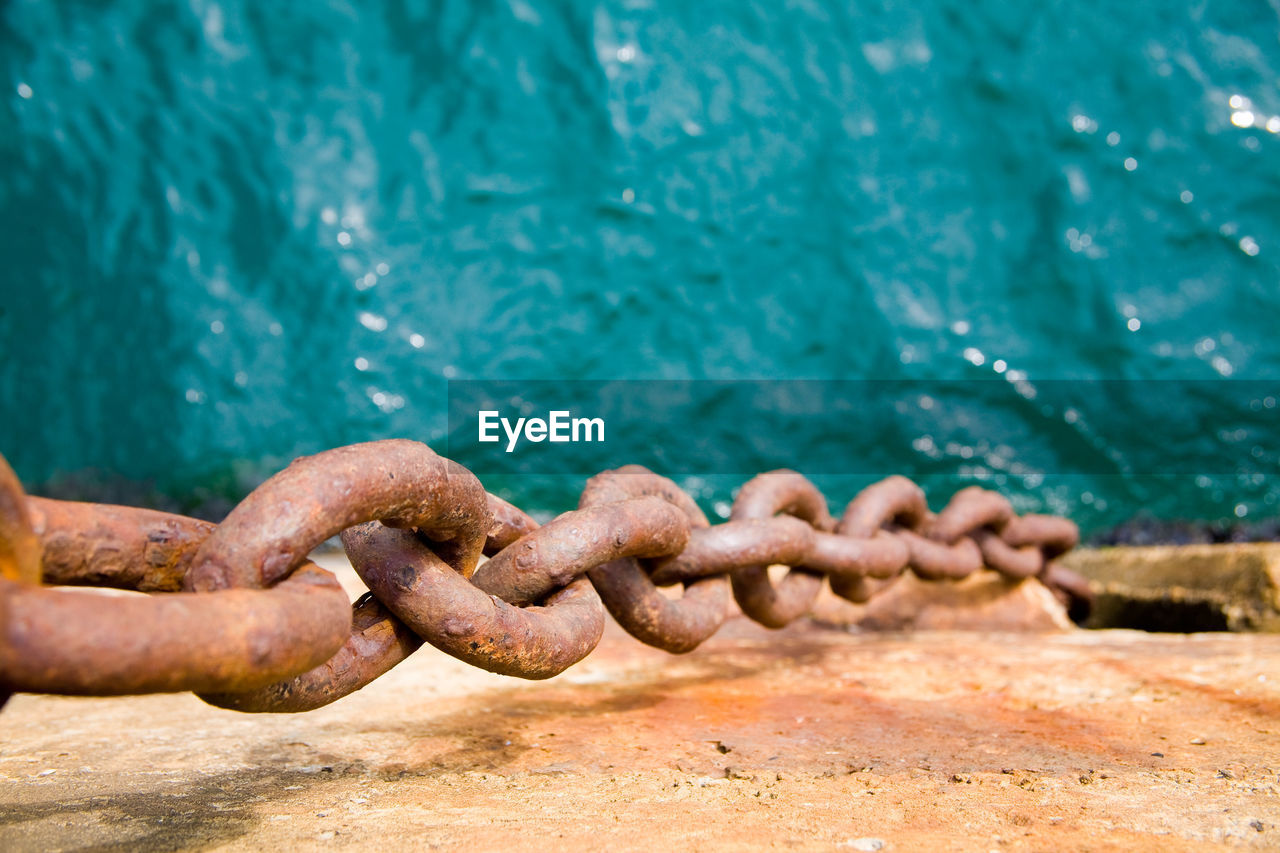 Close-up of rusty chain in sea