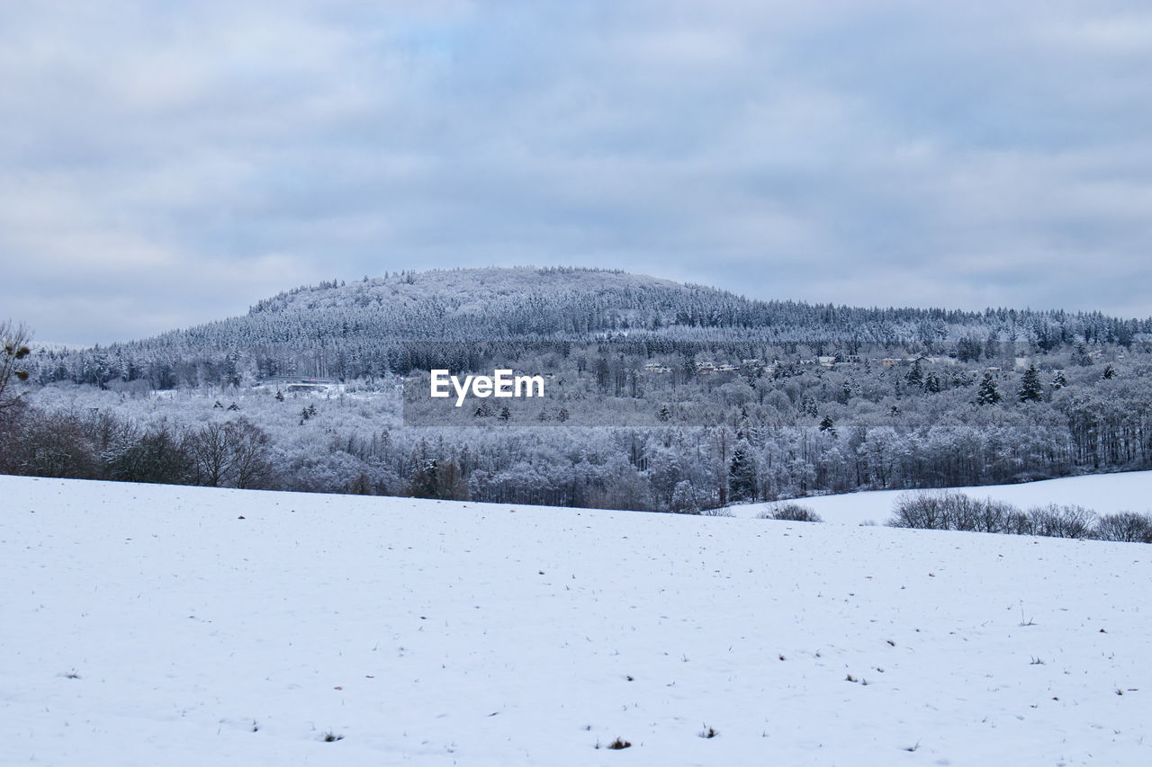 SNOW COVERED FIELD AGAINST SKY