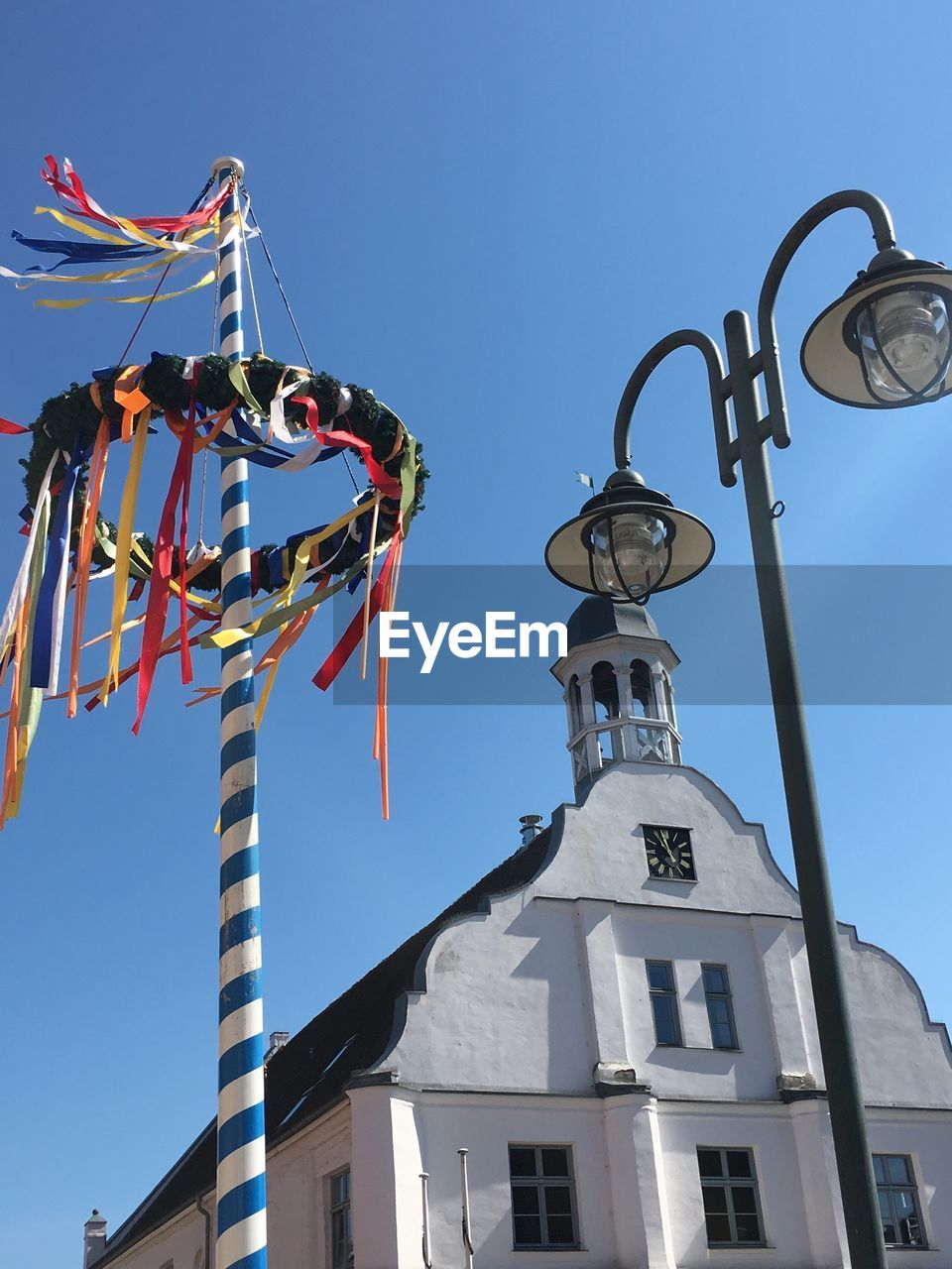 Low angle view of maypole against blue sky