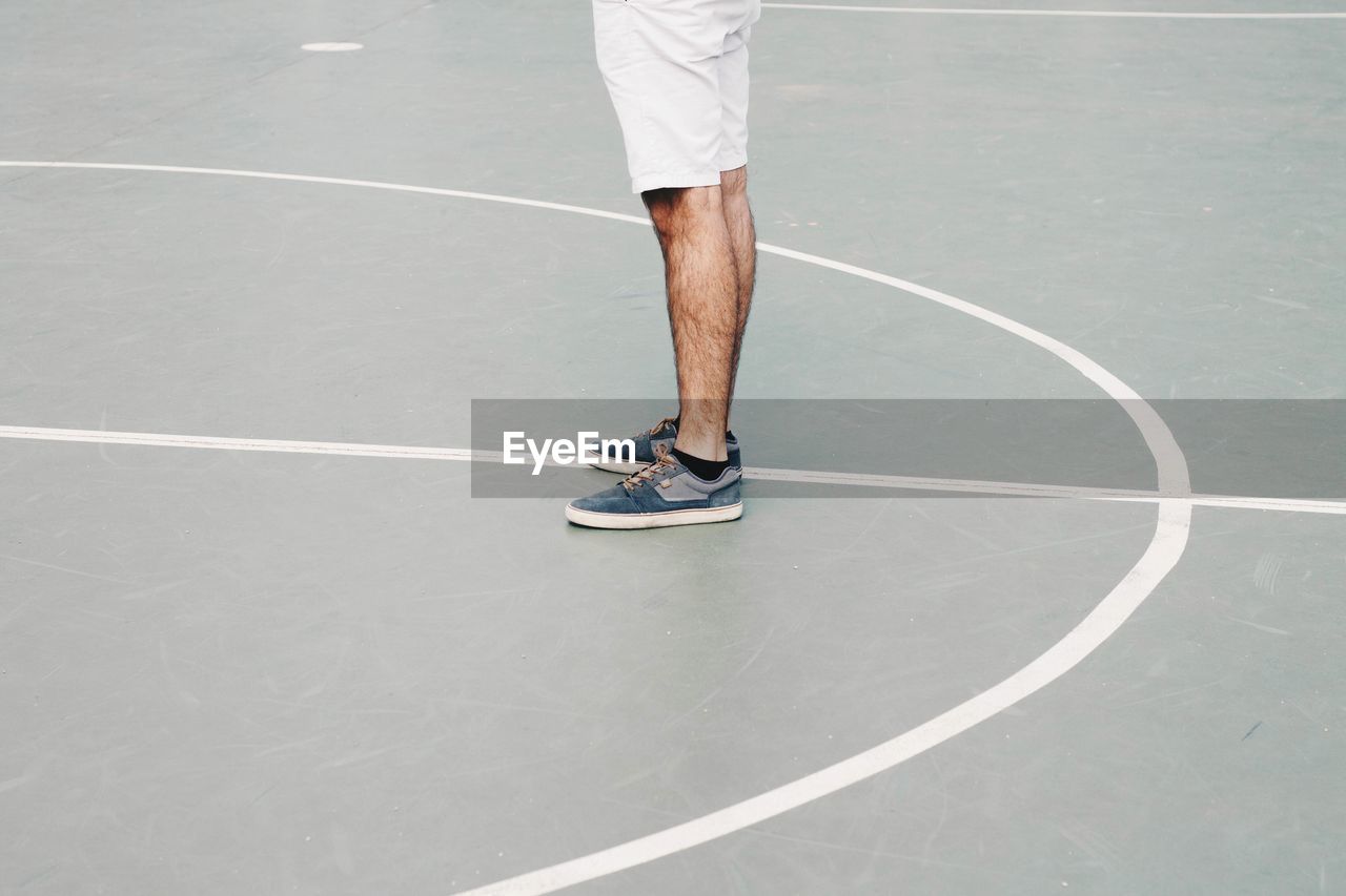 Low section of man standing on basketball court