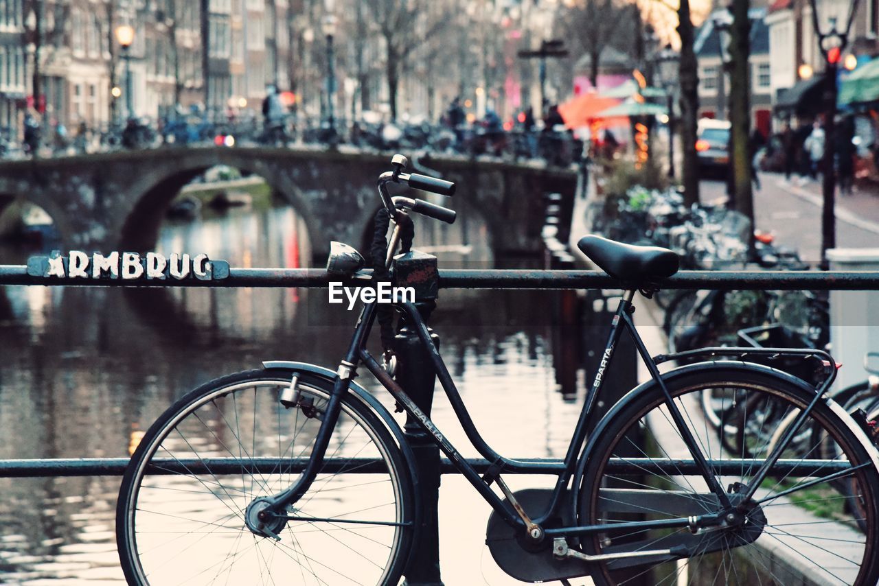 BICYCLE PARKED BY RAILING IN CITY