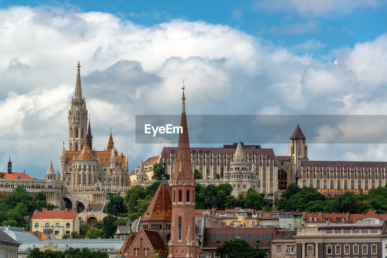 Buildings in city against cloudy sky