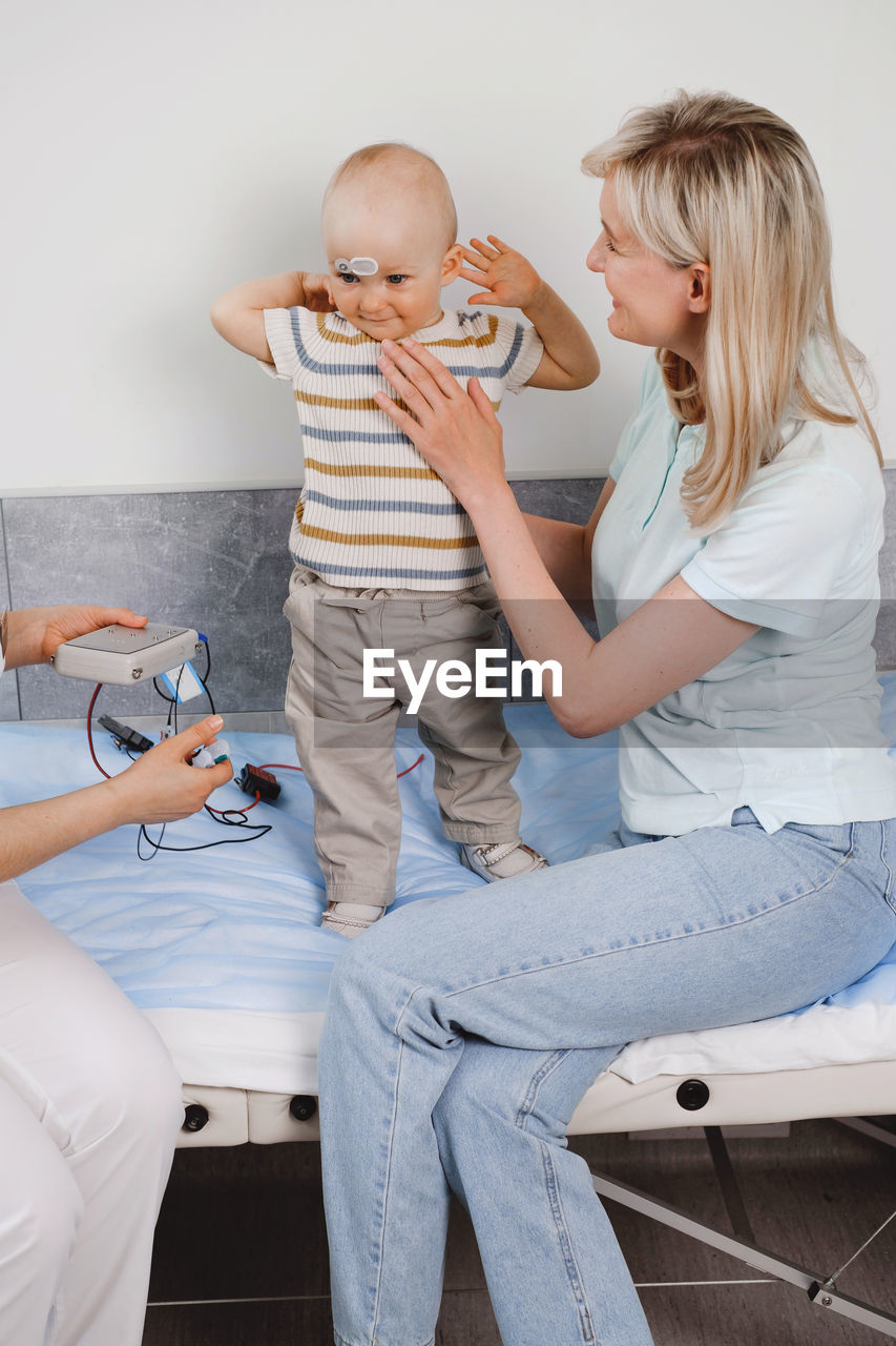 mother and daughter sitting on table at clinic