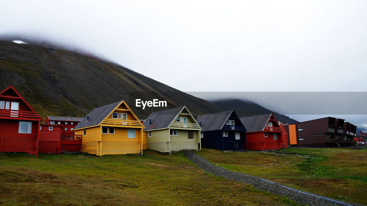 Houses on field against sky