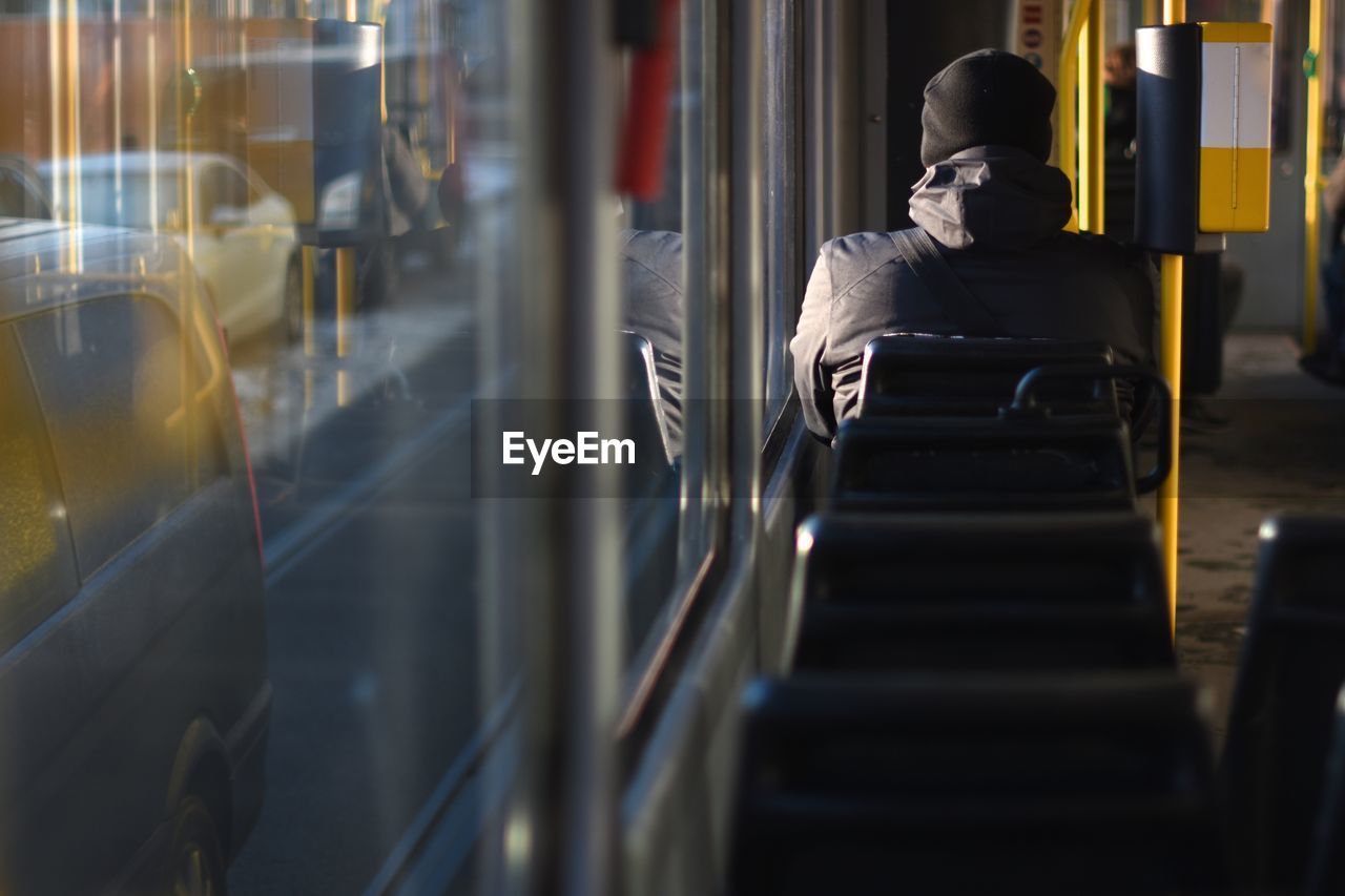 Rear view of man traveling in bus