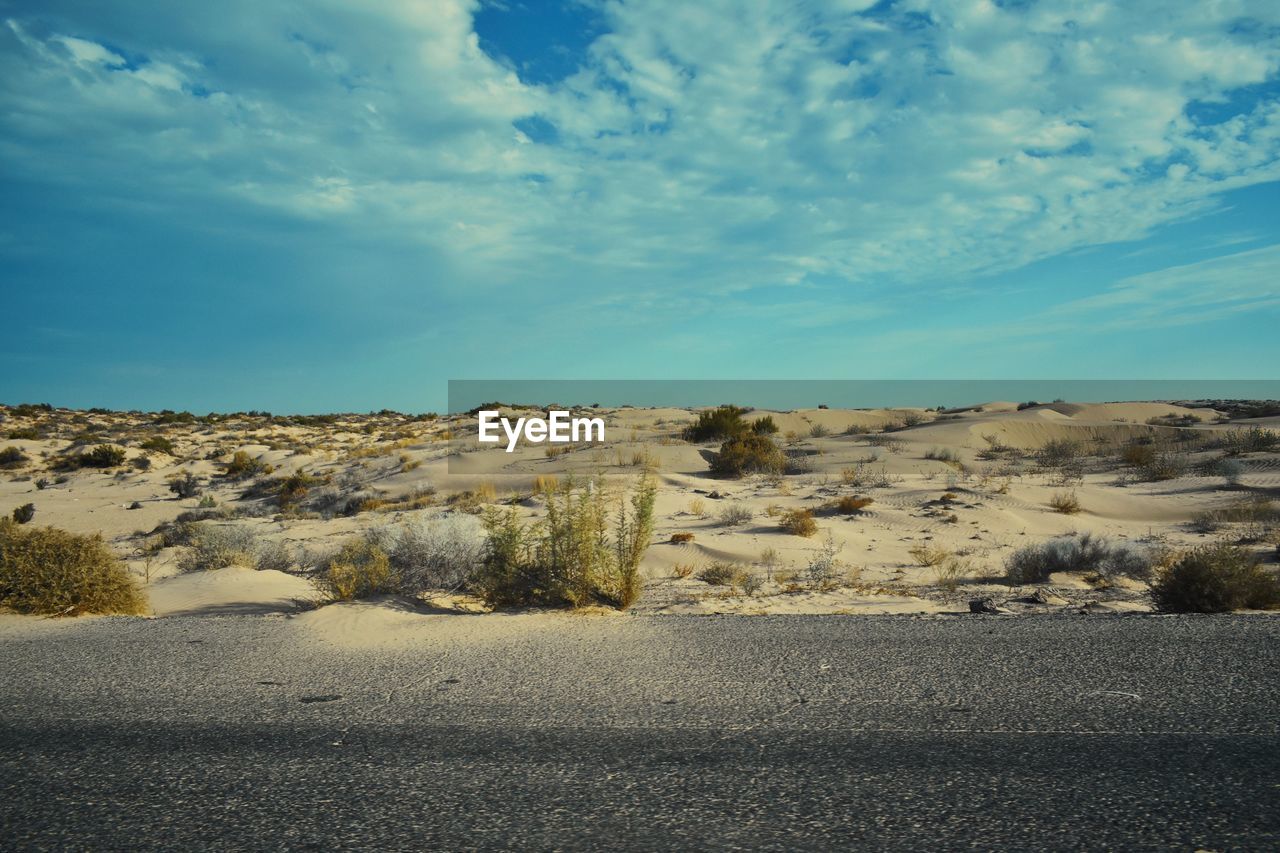 Scenic view of road by land against sky