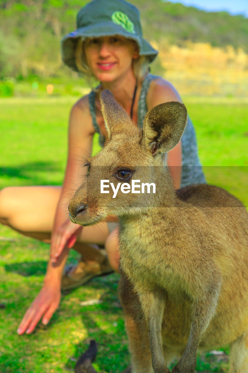 Portrait of cute girl with kangaroo on field