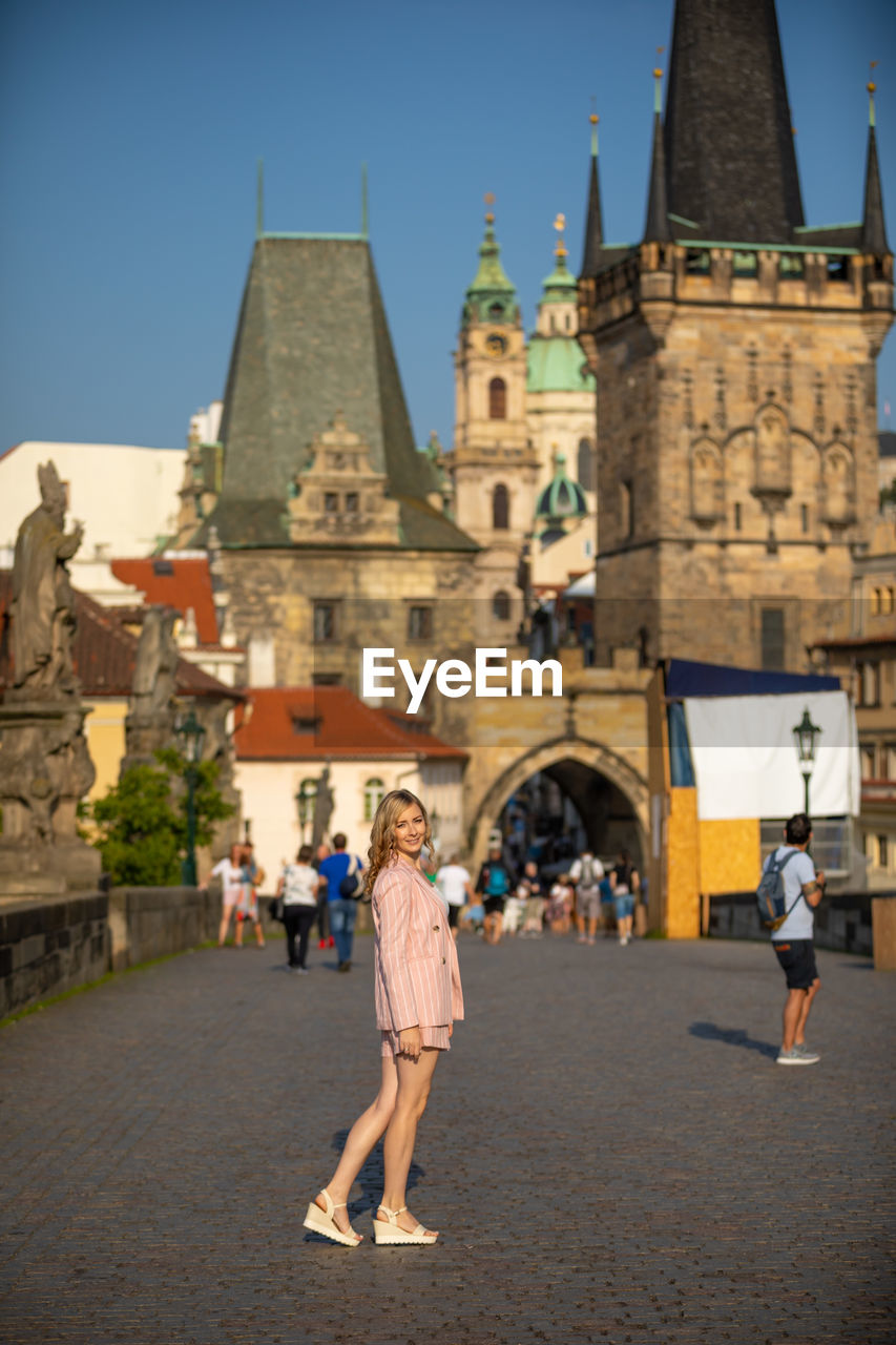 People walking in front of building against sky