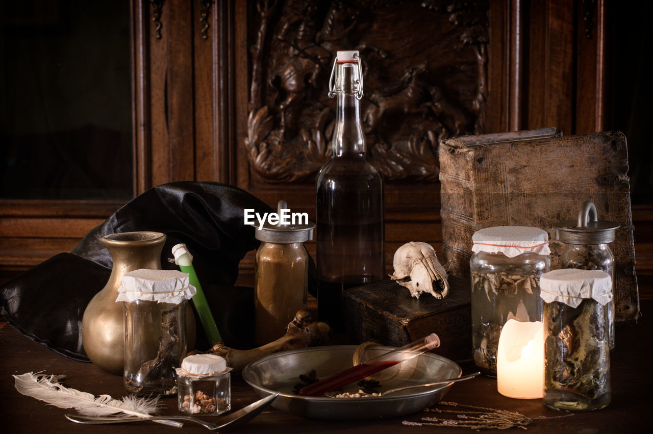 Eerie witches' kitchen ingredients potion recipe, ancient gruesome jars dark candlelight halloween
