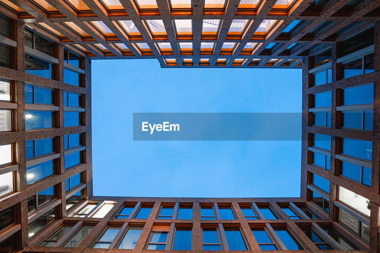 Low angle view of modern building against clear blue sky