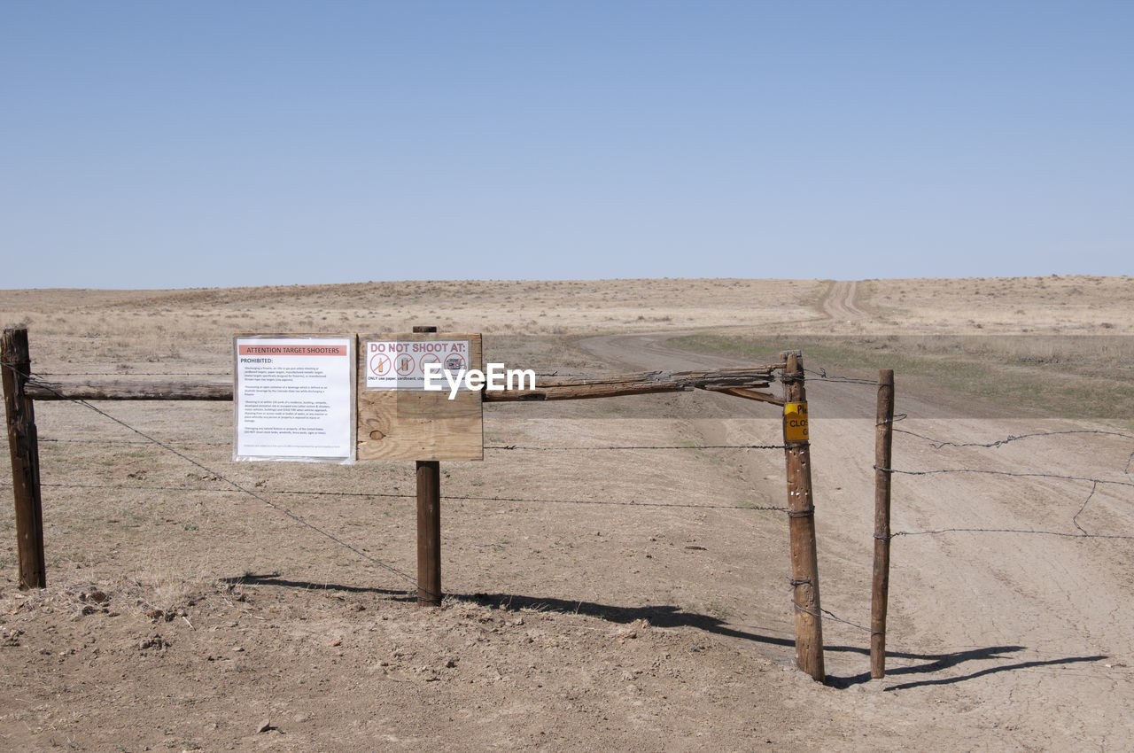 INFORMATION SIGN ON FIELD AGAINST SKY