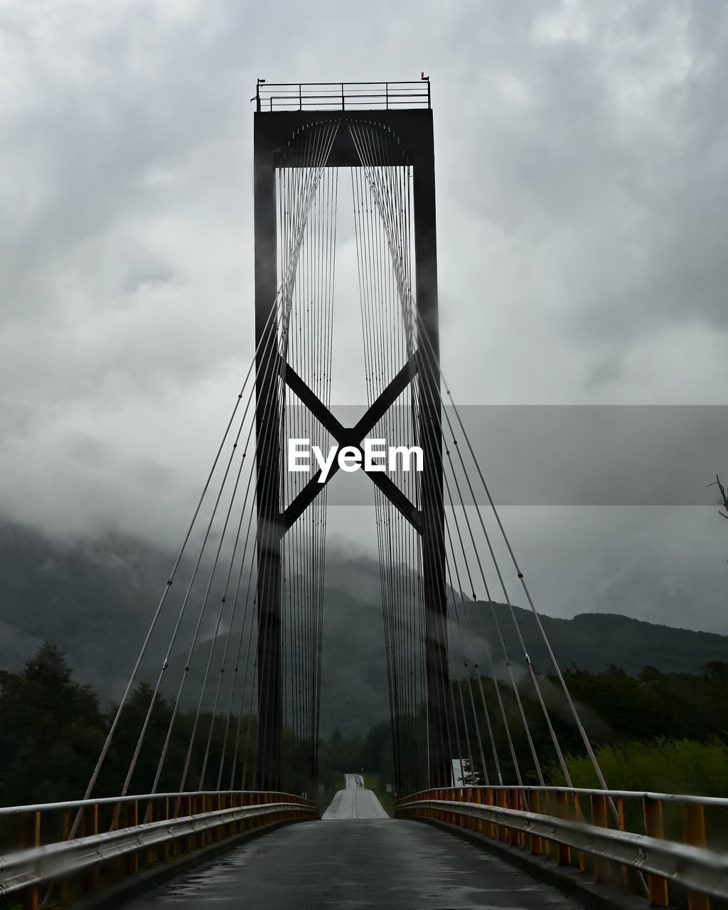 bridge, architecture, cloud, built structure, cable-stayed bridge, sky, transportation, nature, landmark, travel destinations, suspension bridge, city, road, fog, the way forward, engineering, travel, overcast, tourism, environment, water, landscape, outdoors, scenics - nature, building exterior, cloudscape, dramatic sky, street, storm cloud, beauty in nature, storm, day, vanishing point, sign, mountain, highway, cityscape, diminishing perspective, dusk, tranquility