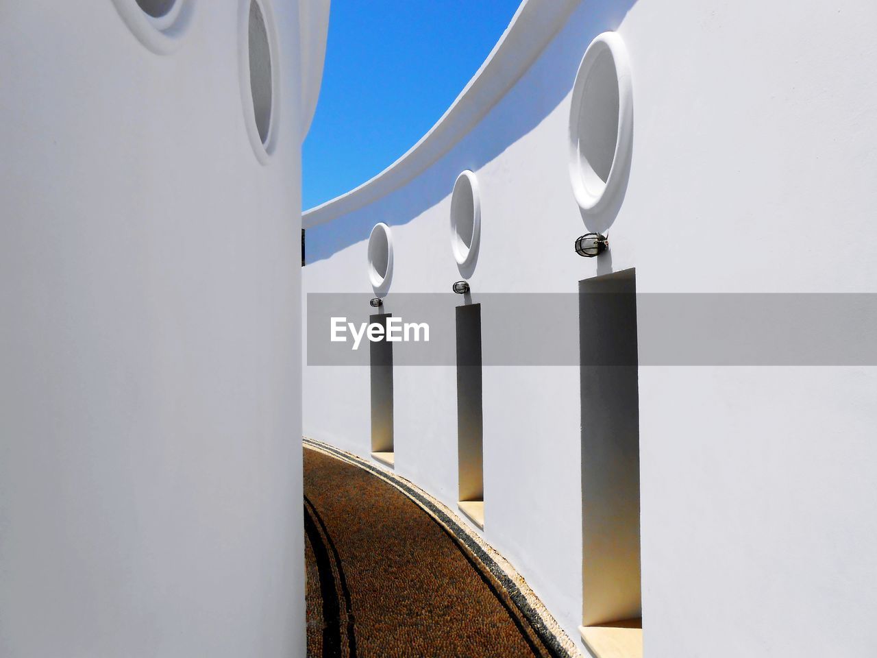 Curved white walls with circular windows and doors. kalithea rhodes