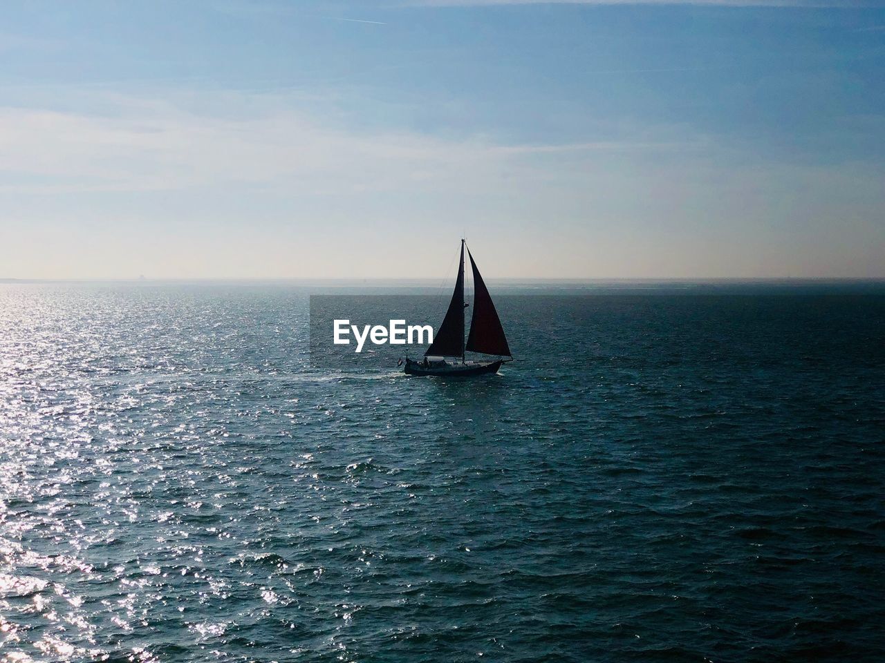 Sailboat sailing on sea against sky