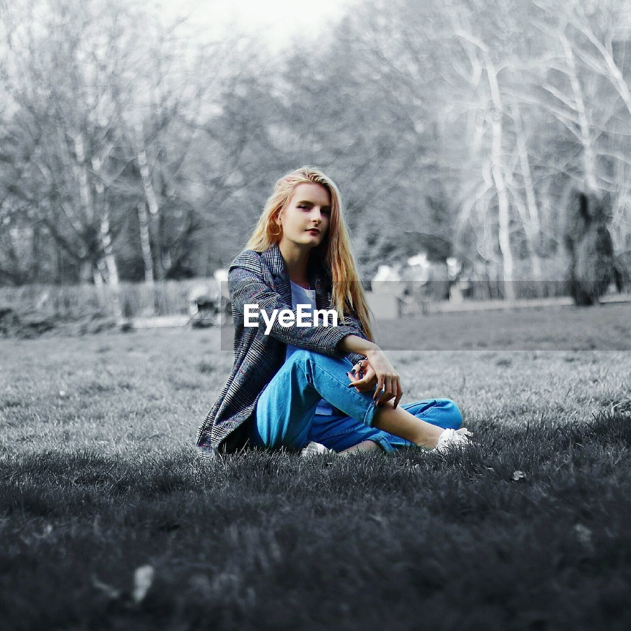 PORTRAIT OF A YOUNG WOMAN SITTING ON TREE