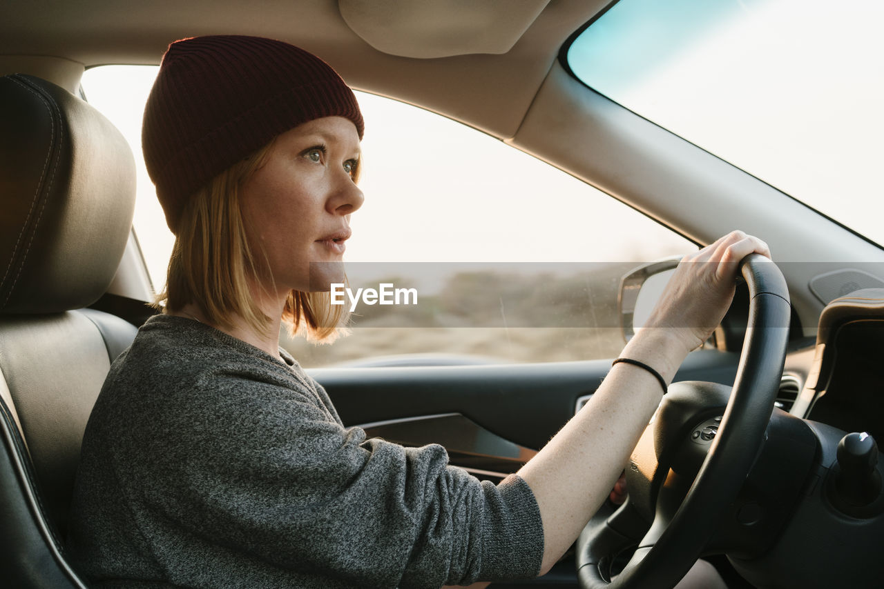 Inside view of woman driving in big sur at sunset