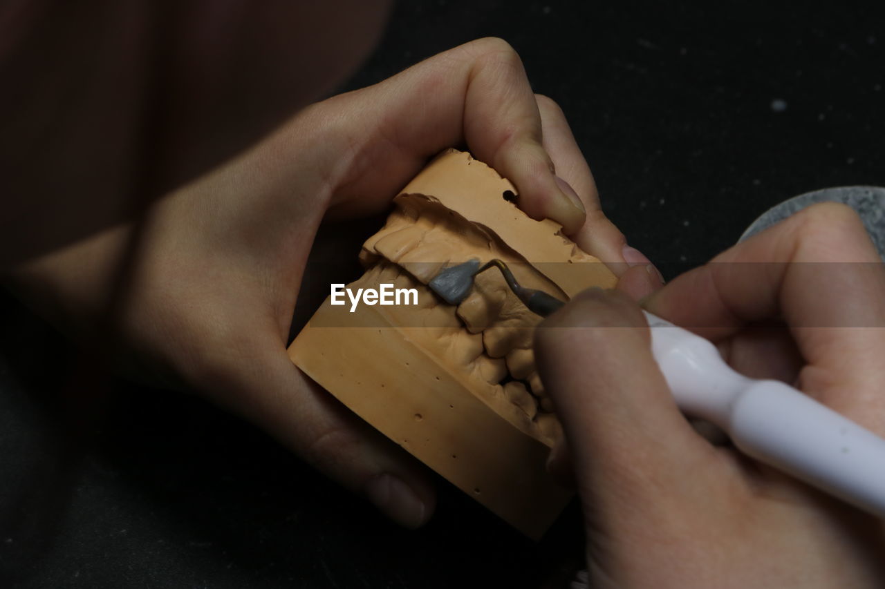 CLOSE-UP OF MAN HAND HOLDING CHOCOLATE