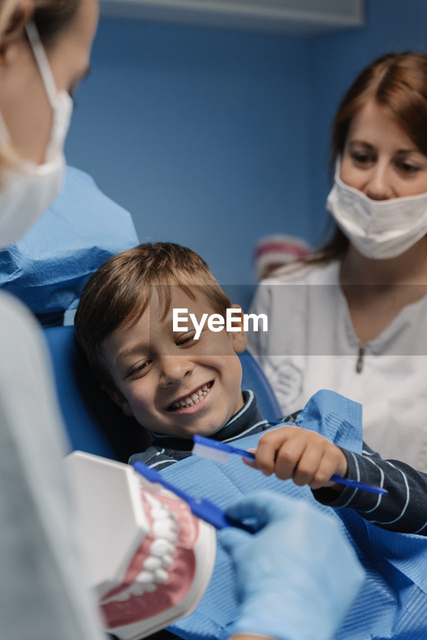 Dentists examining boy in clinic