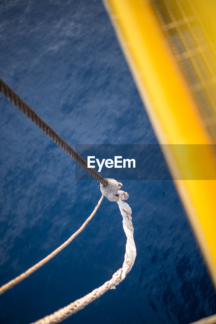 Cropped image of boat with rope on sea