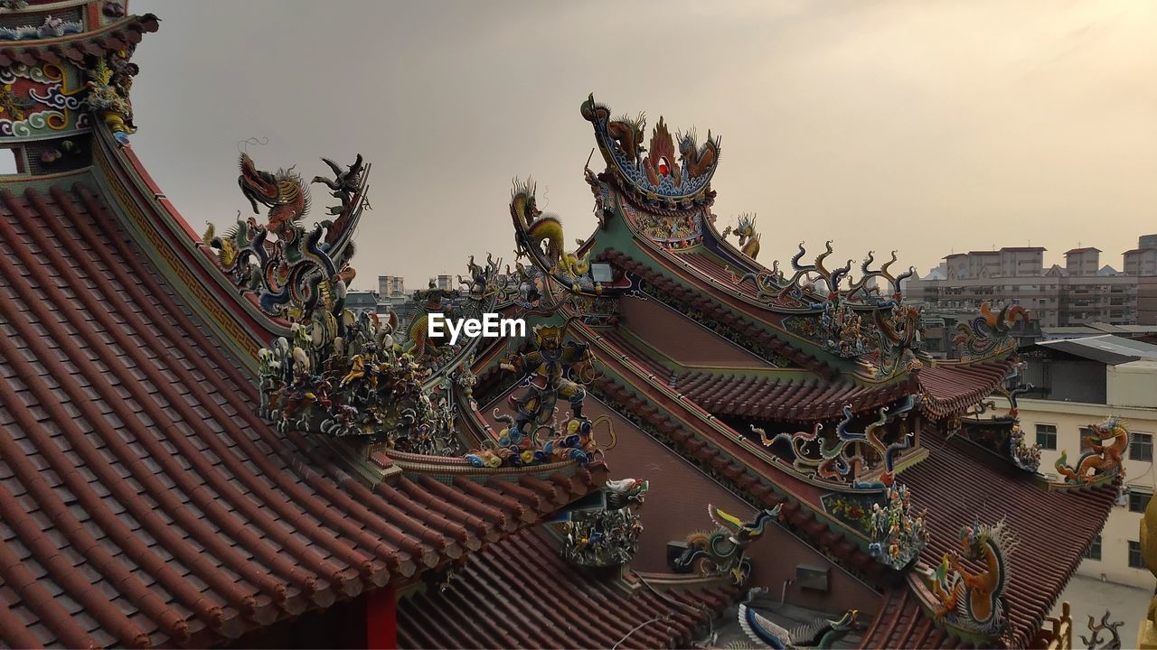 Statues on roof of building against sky