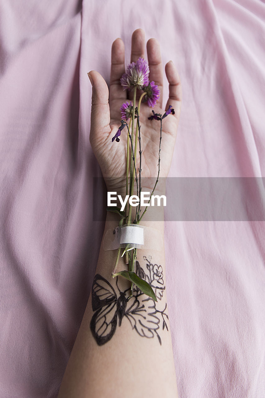 Hand with flowers and tattoos