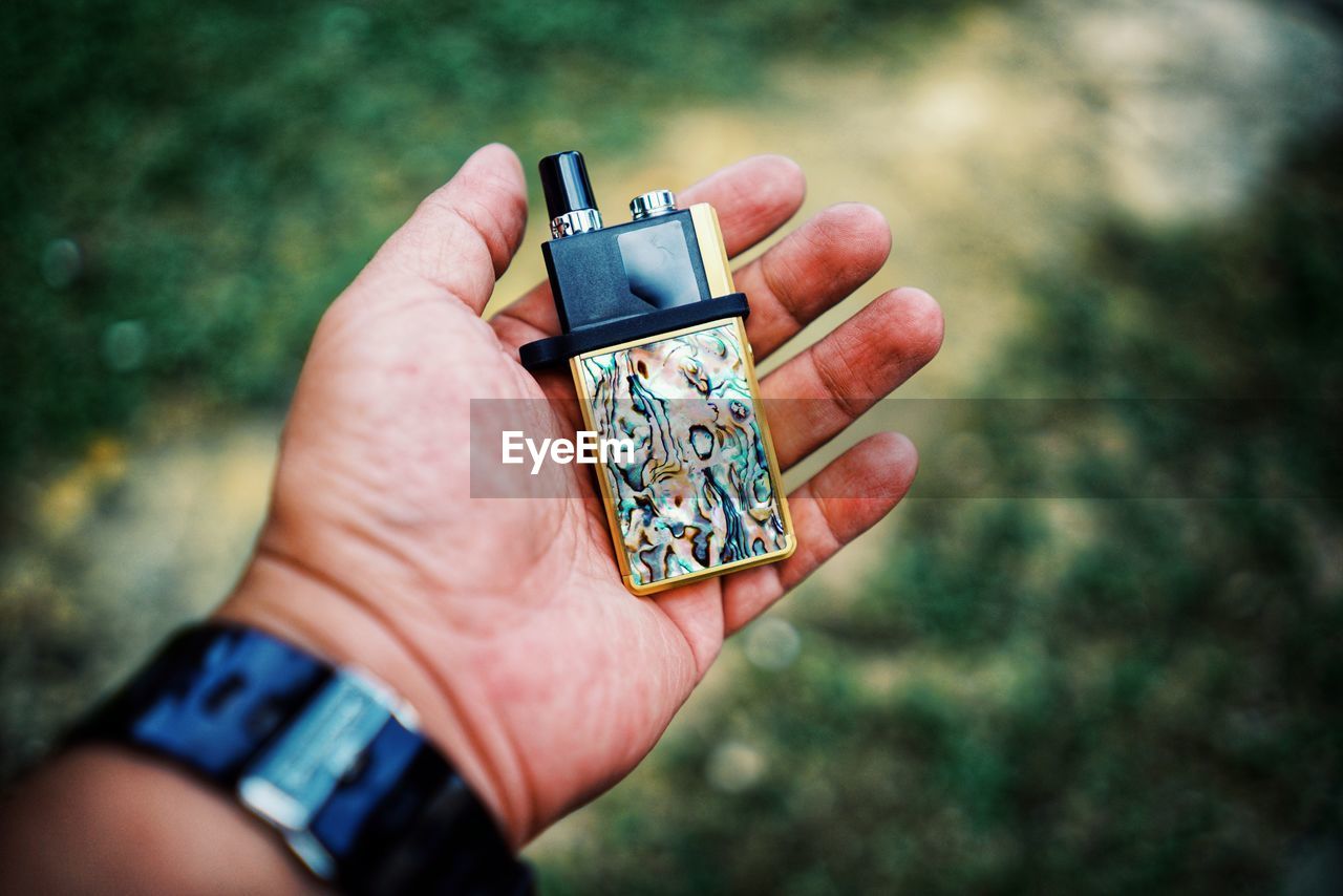 Cropped hand holding cigarette lighter