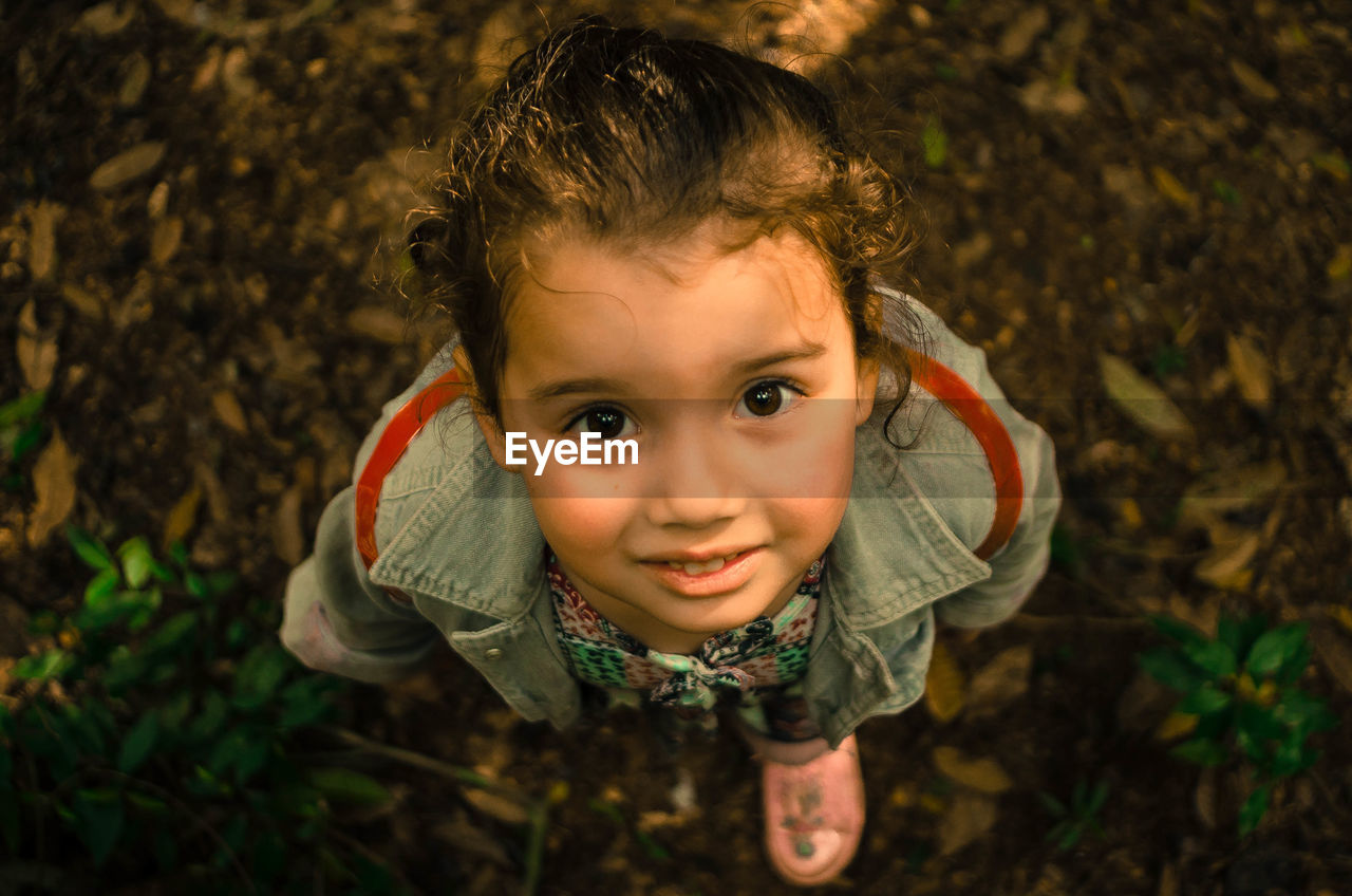 Portrait of cute girl standing on leaves