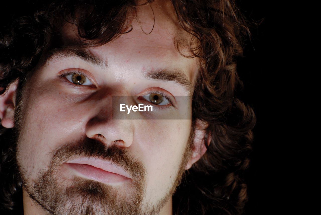 Close-up portrait of man against black background